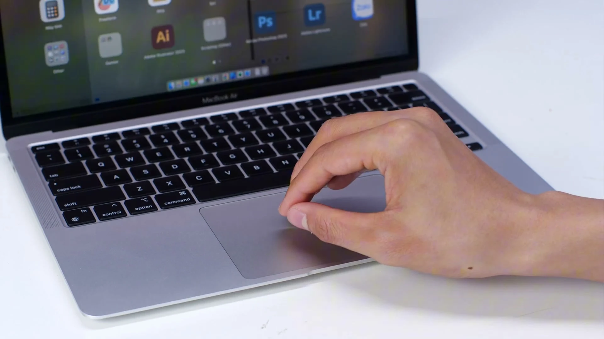 Cận cảnh ngón tay đang thao tác kéo thả mượt mà trên Trackpad của MacBook Air M1 mà không cần dùng chuột rời