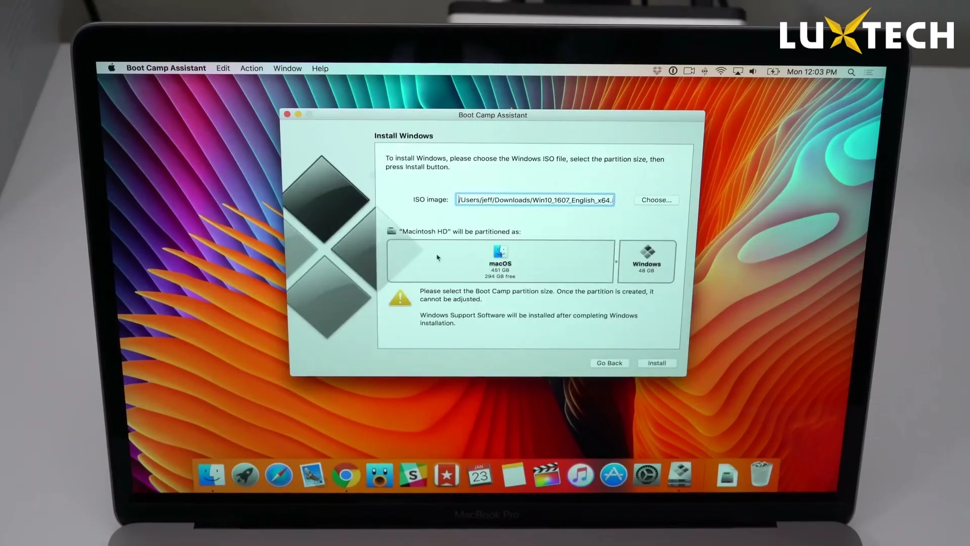 Tay người dùng kéo thanh trượt giữa hai phân vùng macOS và Windows để chia dung lượng